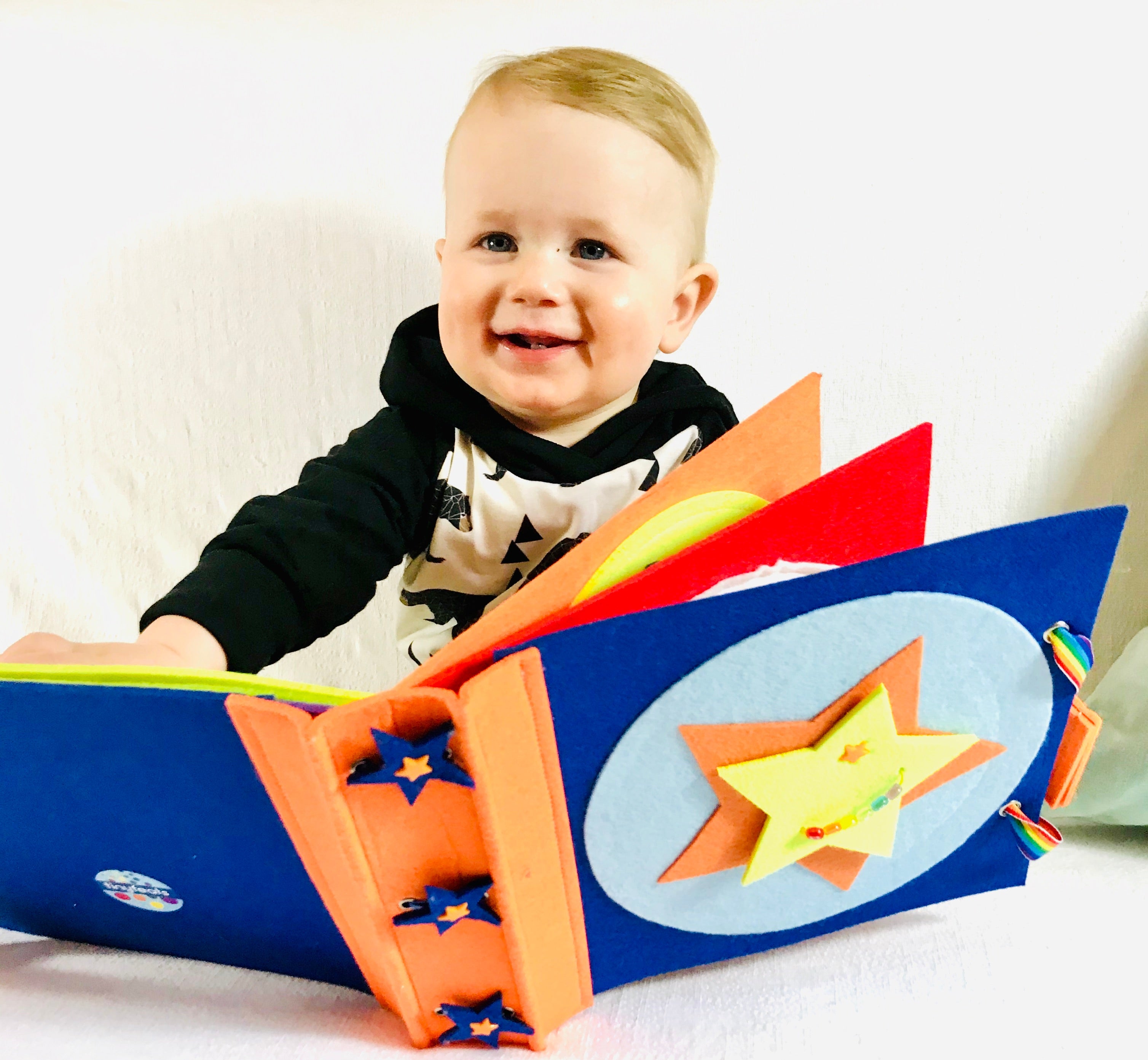 Baby holding a felt developmental toy keepsake gift