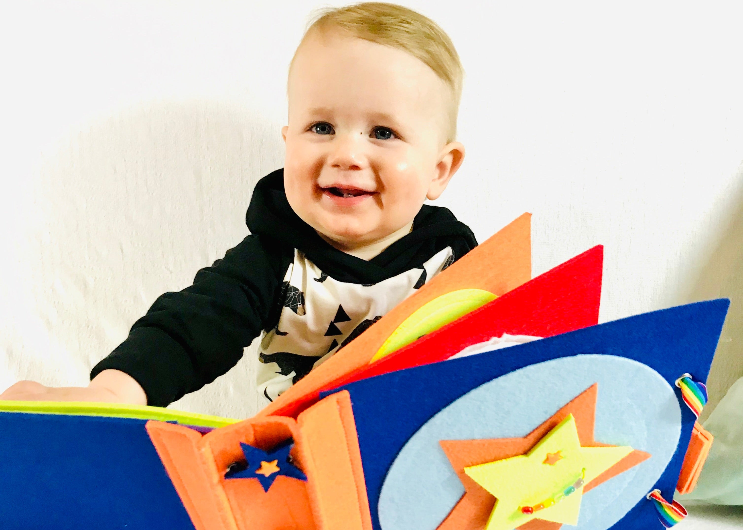 Baby holding a keepsake felt sensory book