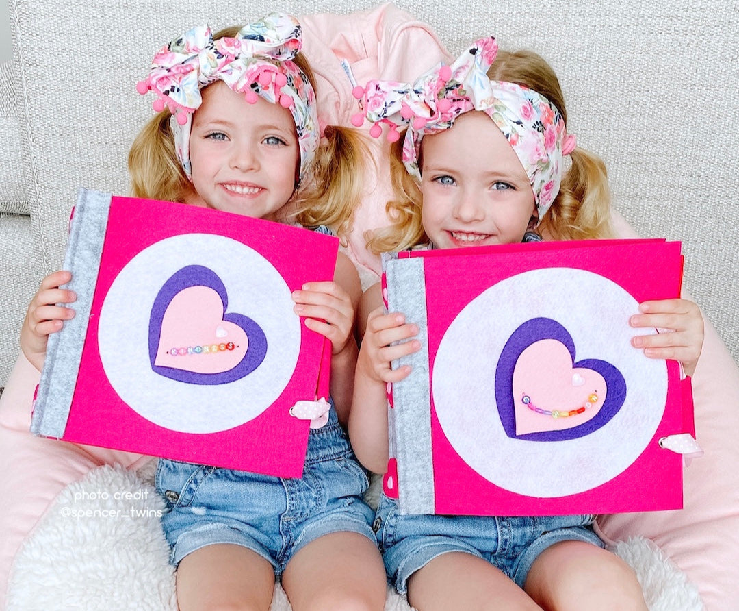 Two happy children holding best selling felt quiet books personalized for them