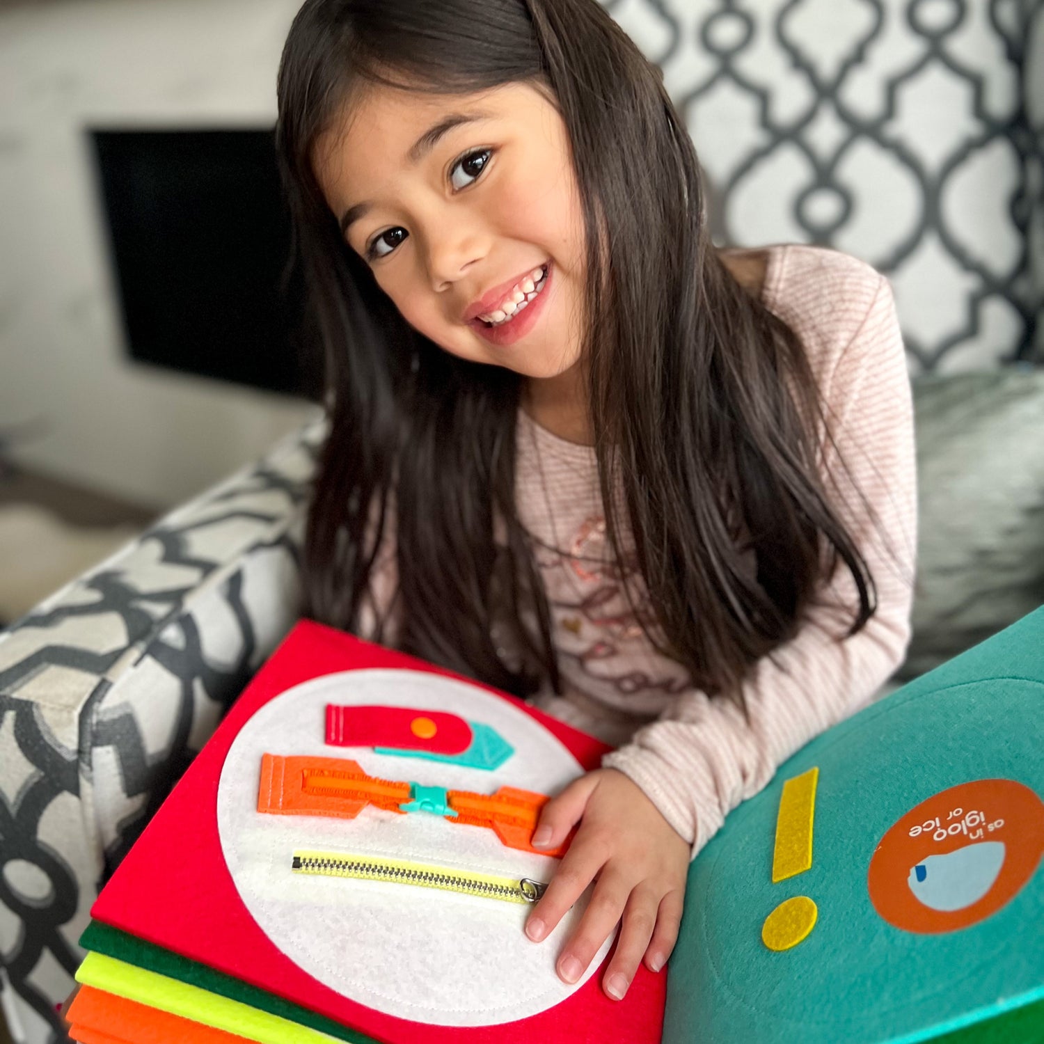 Happy child playing with educational toy felt quiet book