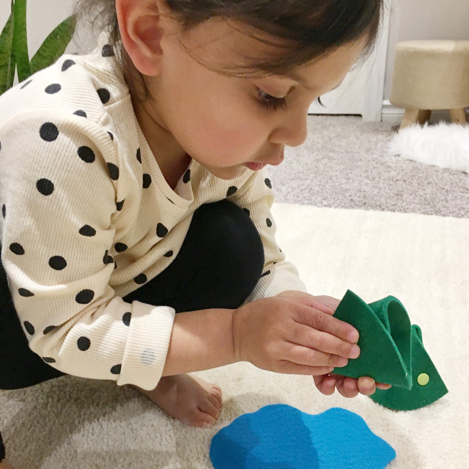 Girl practicing fine motor skills with felt toy that snaps