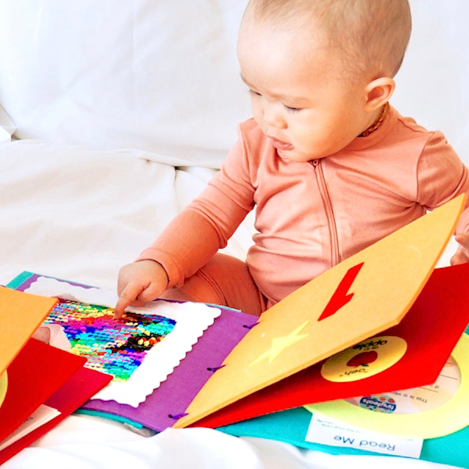 Baby playing with a sensory book for babies